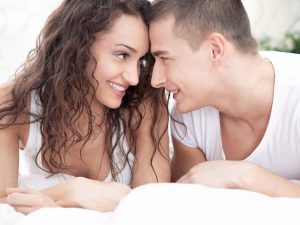 smiling young couple in love lying in bed